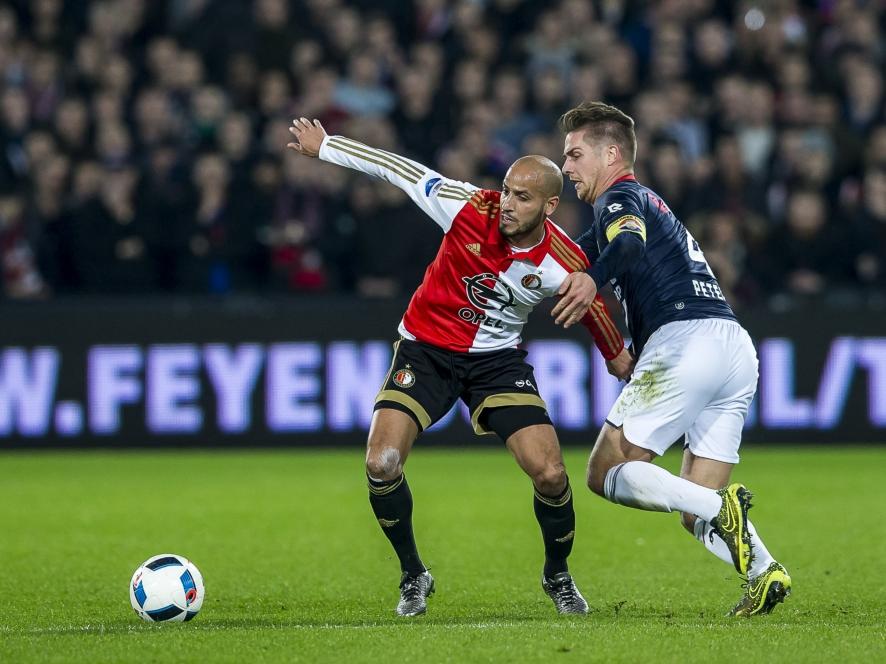 Willem II-aanvoerder Jordens Peters (r.) kan niet meer in balbezit komen, maar houdt Karim El Ahmadi wel vast om te voorkomen dat de middenvelder van Feyenoord door kan voetballen. (17-12-2015)