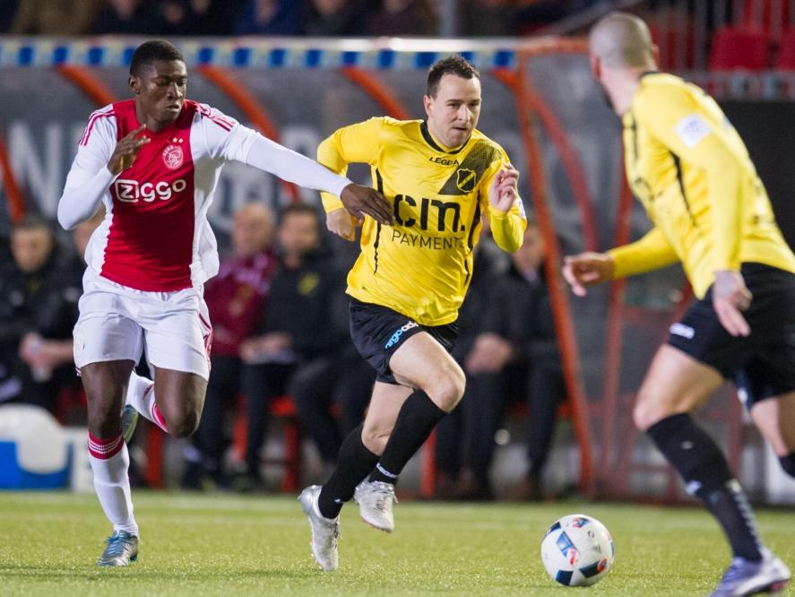 Elton Acolatse (l.) van Jong Ajax probeert NAC-speler Vlatko Lazić bij te houden en moet daarbij zijn armen gebruiken. (25-01-2016)