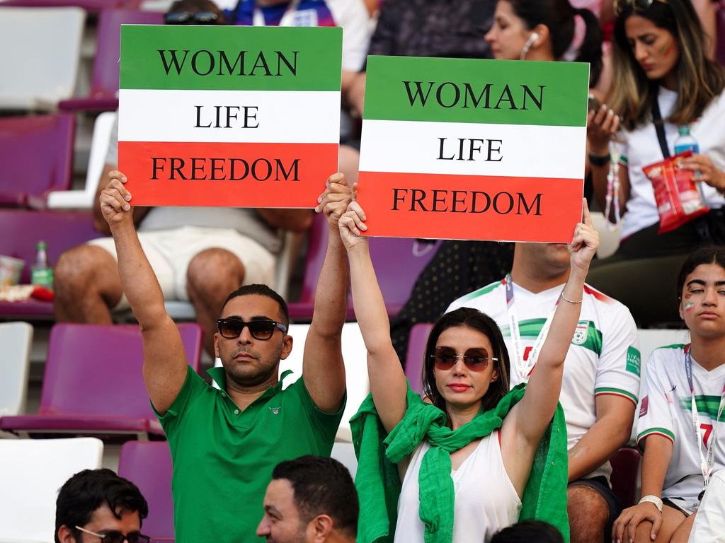 Iranische Fans auf der Tribüne halten vor dem Spiel Schilder mit der Aufschrift 