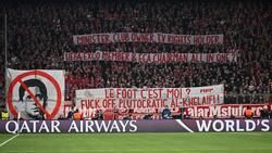 Bayern-Fans zeigen Schmäh-Plakate gegen den Präsident von Paris Saint-Germain, Nasser Al-Khelaifi