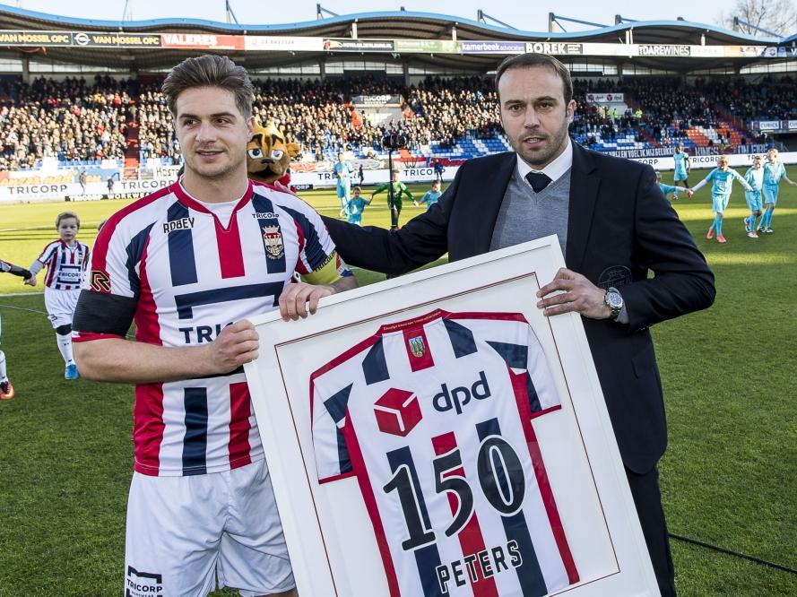 Jordens Peters (l.) krijgt van Joris Mathijsen (r.) een speciaal shirt vanwege zijn 150ste wedstrijd voor Willem II.
