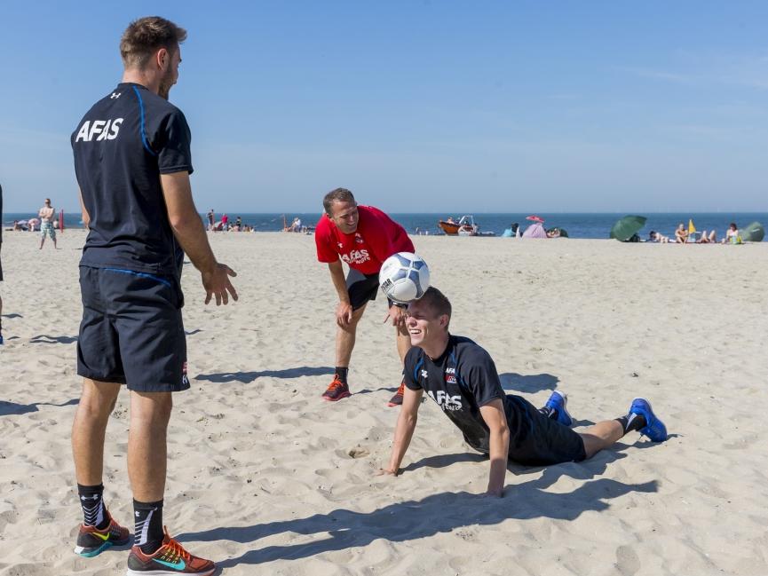 AZ Alkmaar-trainer John van den Brom kijkt toe hoe Aron Jóhannsson zijn oefening uitvoert. Tanković (l.) gooit de bal op, Jóhannsson (r.) moet de bal terug zien te koppen. (03-08-2015)
