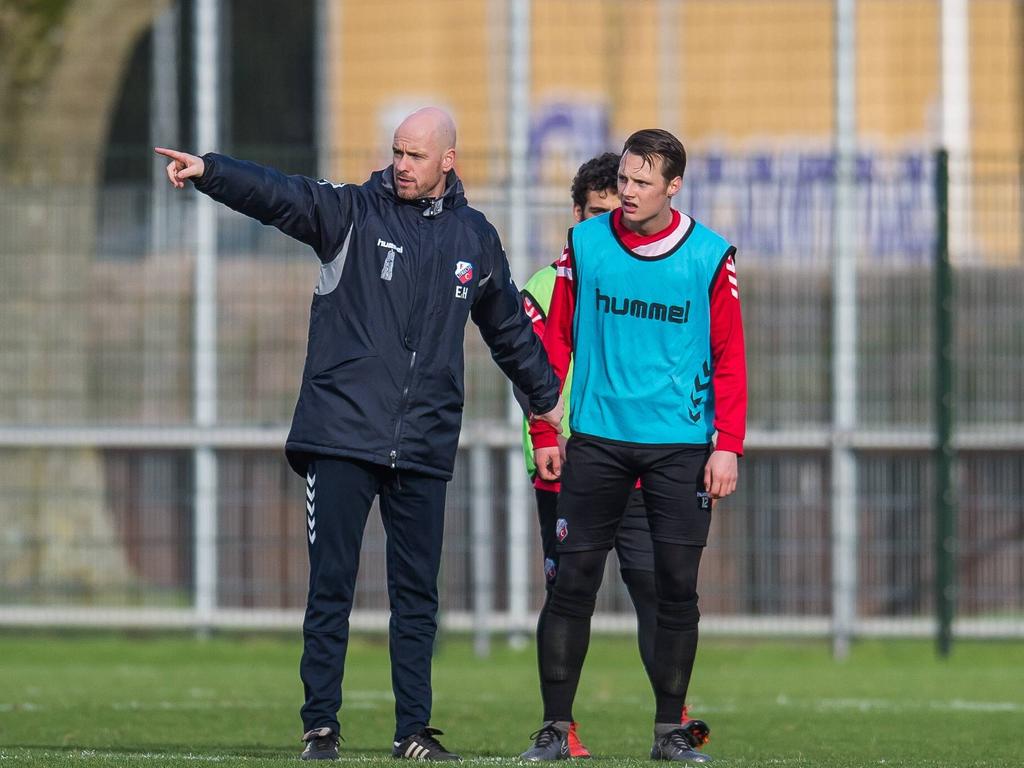 FC Utrecht-trainer Erik ten Hag (l.) geeft instructies tijdens de training, terwijl Jeff Hardeveld (r.) de onderbreking gebruikt om uit te rusten. (11-02-2016)