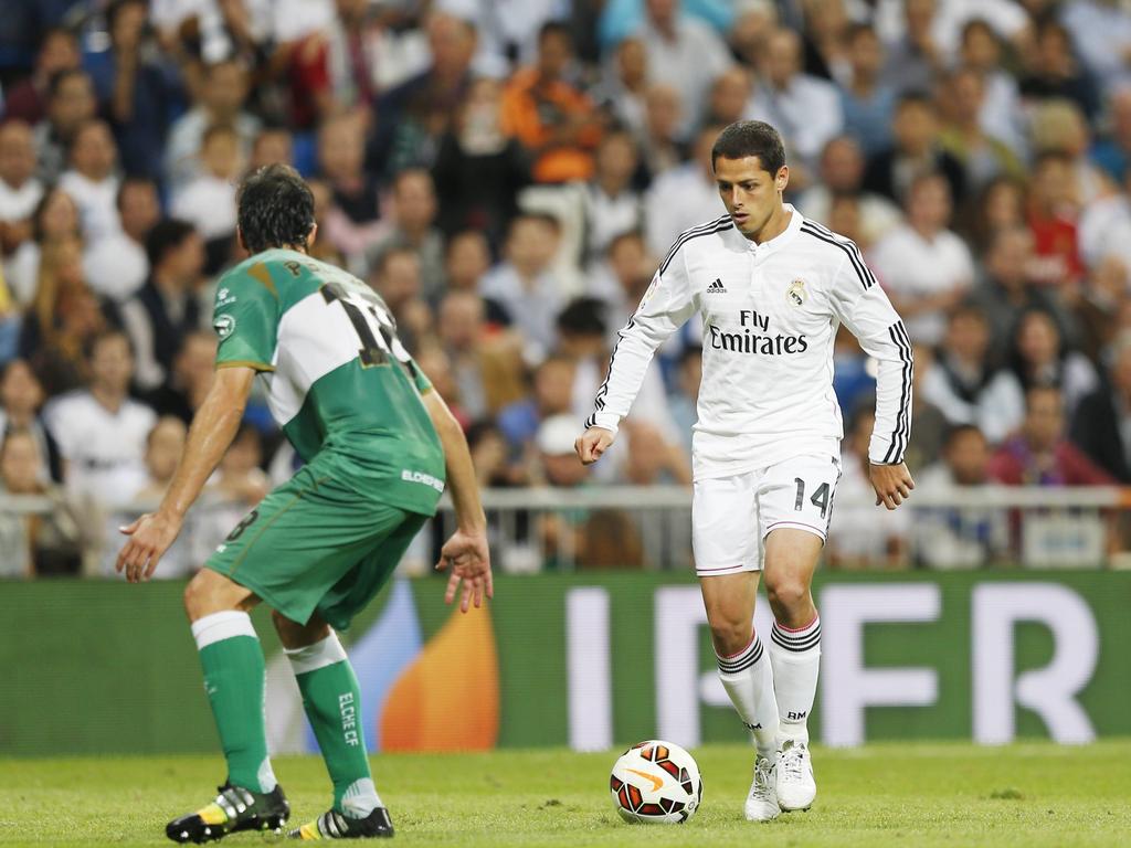 Javier Hernández (r.) dribbelt met de bal aan zijn voet, terwijl Pelegrín zich klaar maakt voor een duel. (02-10-2014)