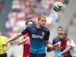 Luc Castaignos (l.) en Stefano Denswil (r.) vechten om de bal. (30-3-2014)