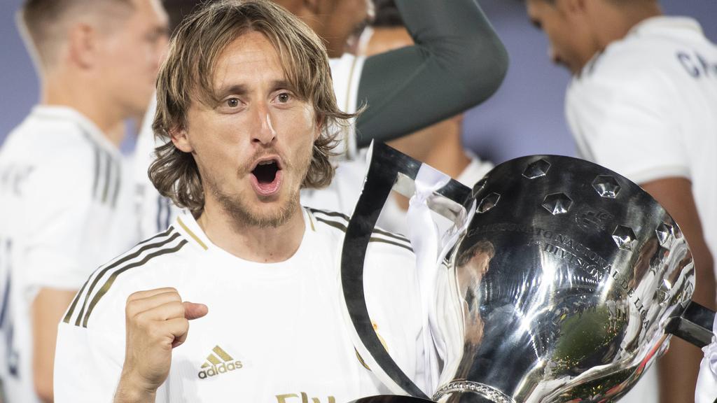 Modric celebra el último título de liga con el trofeo.