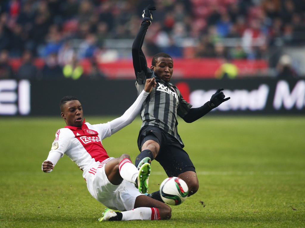 Zowel Riechedly Bazoer (l.) als Kamohelo Mokotjo gaat vol voor de bal tijdens Ajax - FC Twente. (15-02-2015)