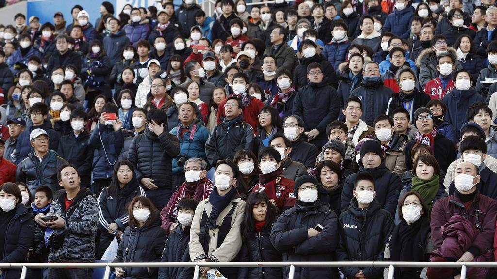 Aficionados del Vissel Kobe japonés con mascarillas en el estadio.