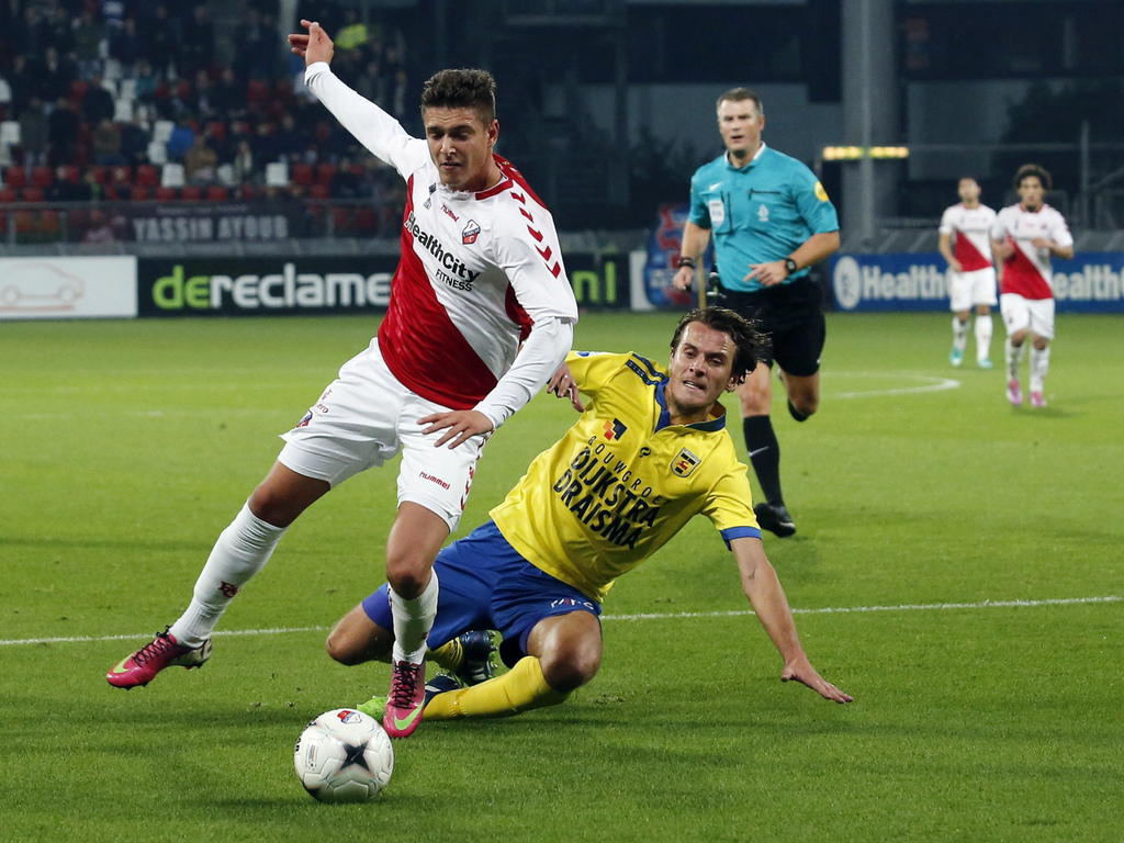 Etiënne Reijnen (r.) begaat een overtreding op Kristoffer Peterson (l.) en veroorzaakt daarmee een strafschop tijdens FC Utrecht - SC Cambuur. (23-11-2014)