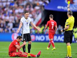 Björn Kuipers geeft Mesut Özil een gele kaart tijdens Duitsland-Polen. (16-06-2016)