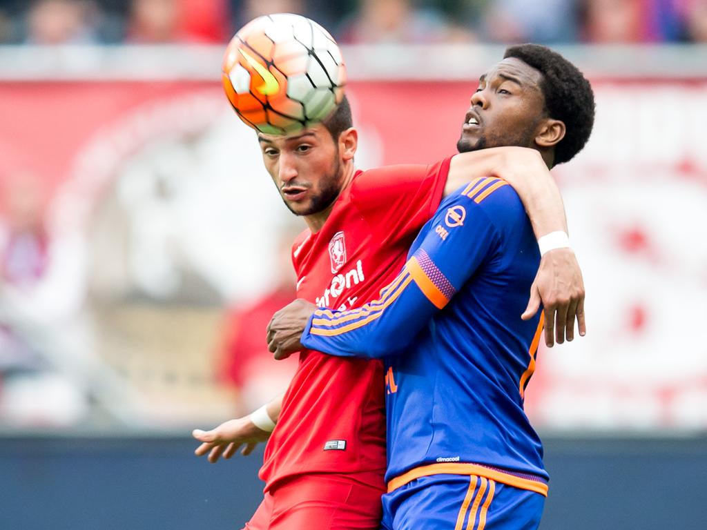 Hakim Ziyech (l.) wint tijdens de competitiewedstrijd FC Twente - Feyenoord het kopduel van Miquel Nelom (r.). (10-04-2016)