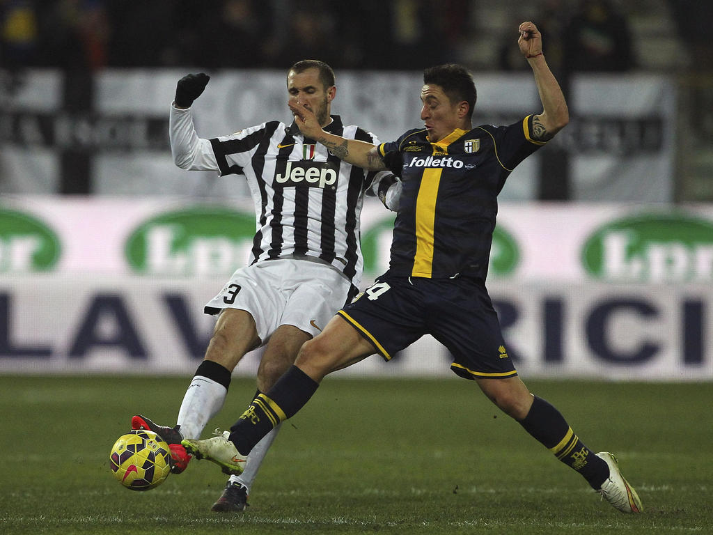 Giorgio Chiellini (l.) deelt een beuk uit aan Cristian Rodríguez (r.) tijdens het bekerduel Parma - Juventus. (28-01-2015)