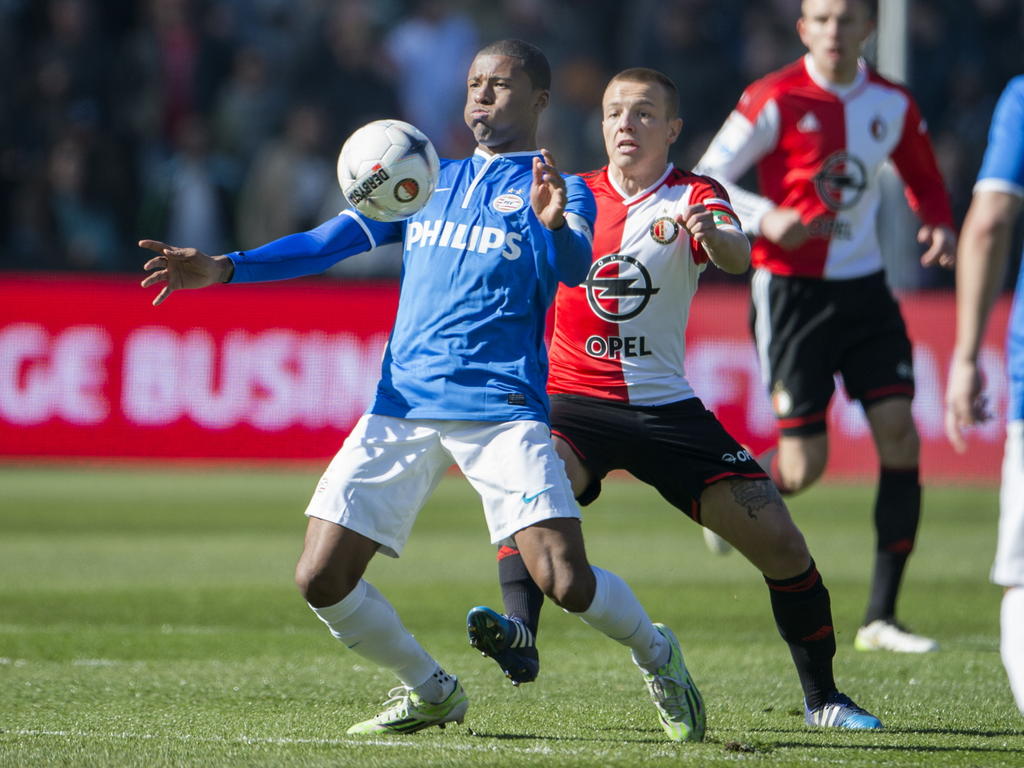 Georginio Wijnaldum (l.) van PSV houdt Feyenoorder Jordy Clasie van de bal. (22-03-2015)