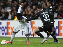 Hans Hateboer (m.) grijpt naar het shirt van Georges-Kévin N'Koudou, om te voorkomen dat de speler van Olympique Marseille uitbreekt. (26-11-2015)