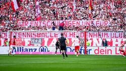 Die Bayern halten ein Transparent mit der Aufschrift "Wir entschuldigen und für die Tennisbälle in Heidenheim, Uli!" in die Luft