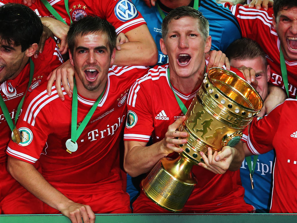 Das Triple 2013 ist perfekt: Die Führungsspieler des FC Bayern München, Philipp Lahm und Bastian Schweinsteiger, präsentieren stolz den soeben gewonnenen DFB-Pokal. (1.6.2013)