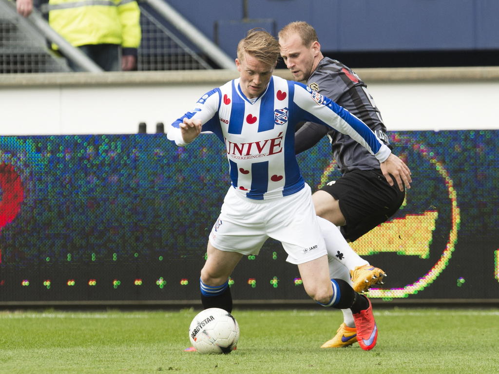 Sam Larsson (l.) draait weg bij Frank van der Struijk (r.) tijdens het competitieduel sc Heerenveen - Willem II. (25-04-2015)