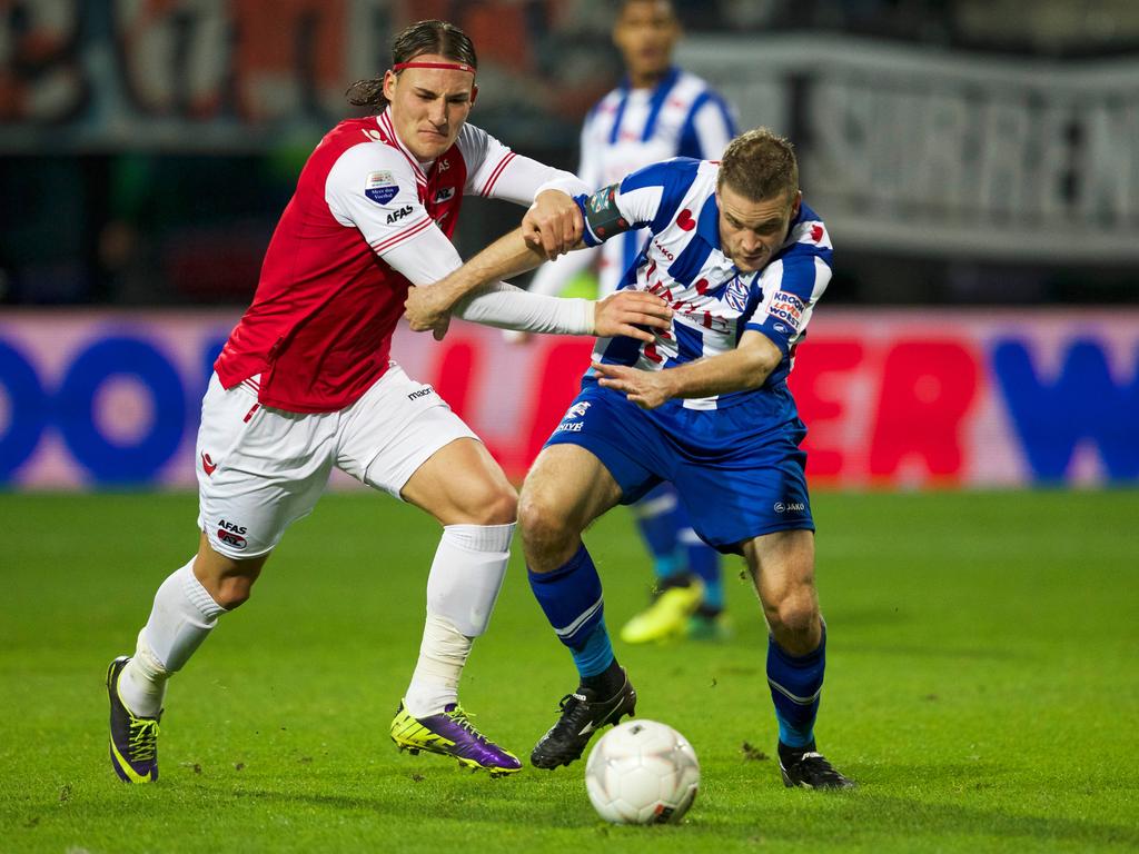 Twee fysiek sterke middenvelders, Joey van den Berg (r.) en Nemanja Gudelj (l.), vechten een duel uit tijdens de bekerwedstrijd tussen AZ en sc Heerenveen. (18-12-2013)