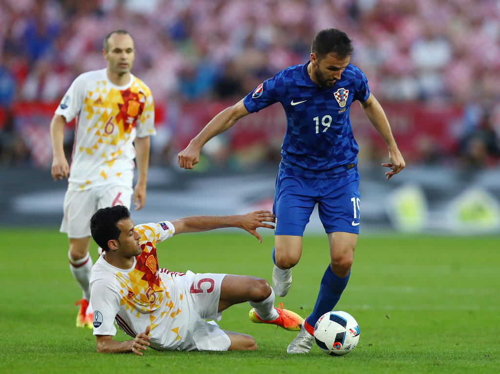 Iniesta mira como Busquets lucha con el croata Badelj. (Foto: Getty)