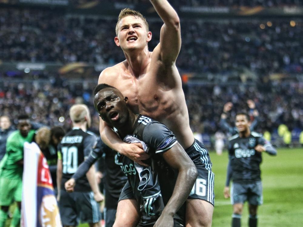 Davinson Sánchez wordt besprongen door Matthijs de Ligt. Het centrale duo van Ajax viert feest met de supporters na het bereiken van de finale van de Europa League, ten koste van Olympique Lyon. (11-05-2017)