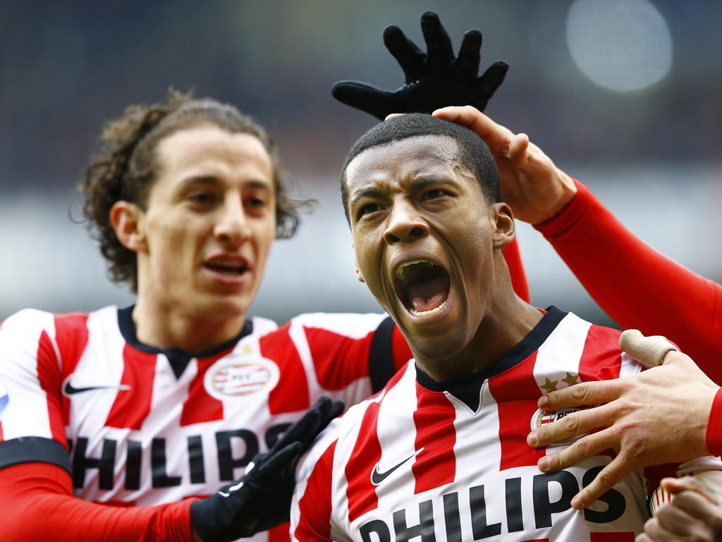PSV'er Georinio Wijnaldum (r.) viert zijn openingstreffer tegen FC Groningen met Andrés Guardado. (15-03-2015)