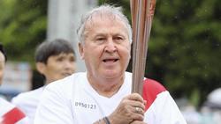 Zico trägt die olympische Fackel