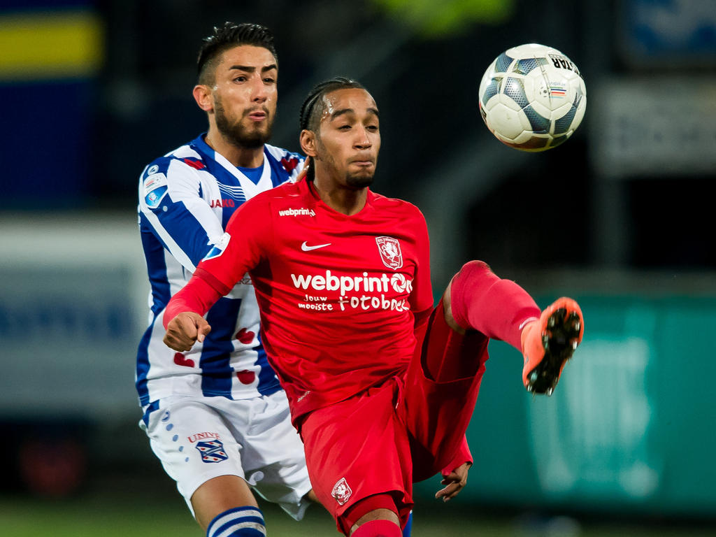 Caner Çavlan (l.) zet Jerson Cabral (r.) flink onder druk tijdens de competitiewedstrijd sc Heerenveen - FC Twente. (06-02-2016)