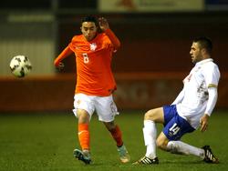 Abdelhak Nouri (l.) moet een tackle van Filip Bainović (r.) ontwijken tijdens het kwalificatieduel Nederland - Servië onder 19. (26-03-2015)
