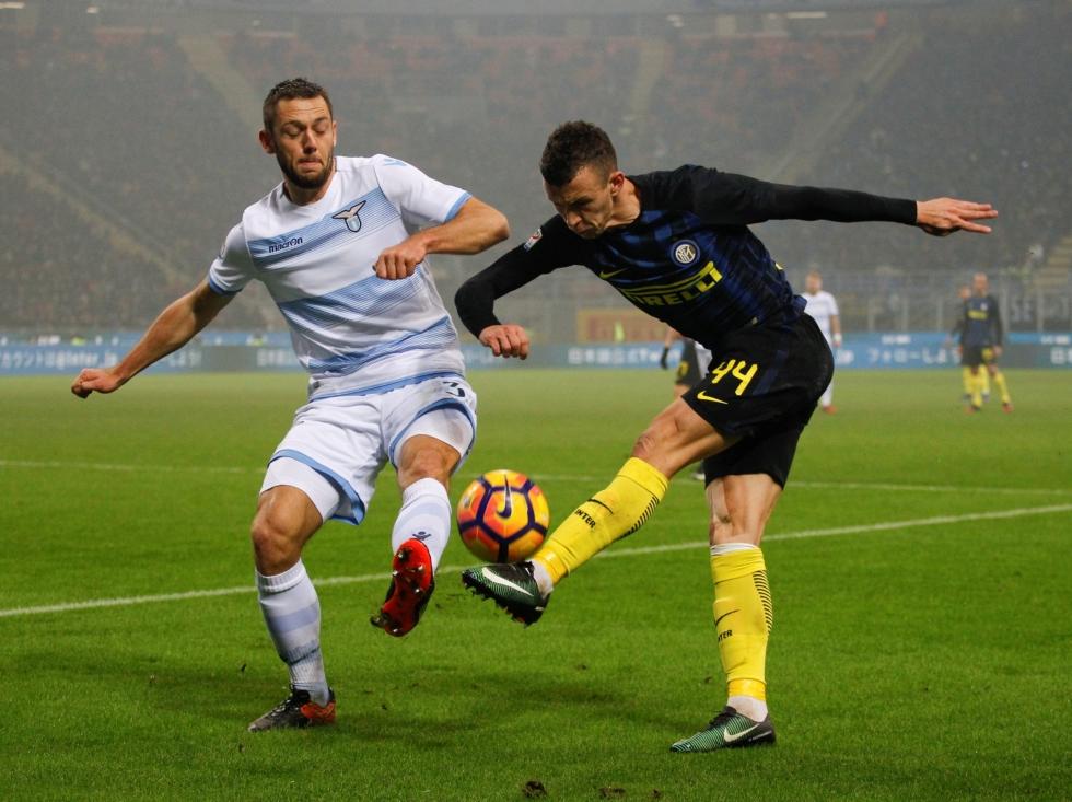 Stefan de Vrij (l.) probeert een voorzet van Ivan Perišić (r.) te blokken tijdens het competitieduel tussen Lazio Roma en Inter. (21-12-2016)