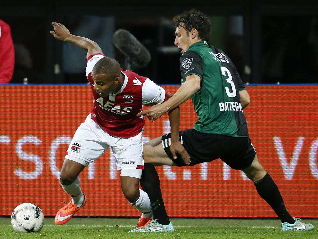 Mikhail Rosheuvel (l.) ontdoet zich van verdediger Eric Botteghin (r.) tijdens de competitiewedstrijd AZ - FC Groningen. (25-11-2014)