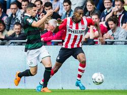 Bryan Linssen (l.) probeert Joshua Brenet (r.) af te stoppen tijdens de Eredivisie-wedstrijd tussen PSV en FC Groningen. (16-08-2015)