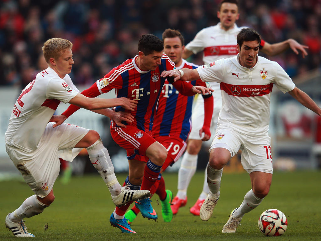 Bayern Münchens Angreifer Robert Lewandowski (M.) in der Zange von zwei Stuttgartern