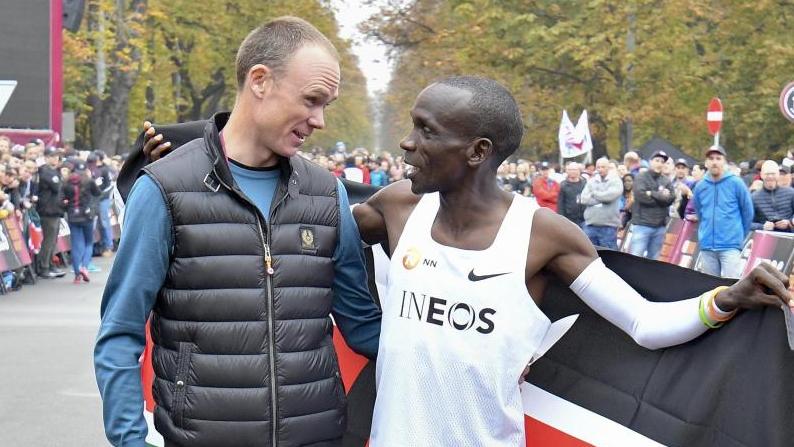 Radstar Chris Froome beglückwünscht Marathon-Weltrekordhalter Eliud Kipchoge in Wien direkt nach dem Zieleinlauf. Foto: Herbert Neubauer/APA/dpa Radstar Chris Froome beglückwünscht Marathon-Weltrekordhalter Eliud Kipchoge in Wien direkt nach dem Zieleinlauf. Foto: Herbert Neubauer/APA/dpa