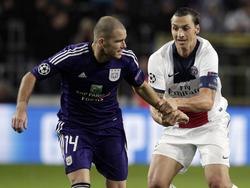 Bram Nuytinck (l.) probeert Zlatan Ibrahimović (r.) van zich af te schudden tijdens Anderlecht - Paris Saint-Germain. (23-10-2013)