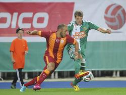 Nordin Amrabat (l.) probeert Ferdinand Weinwurm (r.) de bal af te pakken tijdens de oefenwedstrijd Rapid Wien - Galatasaray. (23-7-2014)