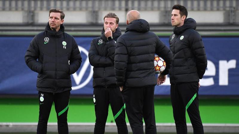 Vor dem Abflug nach Sevilla war Corona wieder ein Thema: Wolfsburgs Trainer Florian Kohfeldt (l.) steht mit seinem Team zusammen