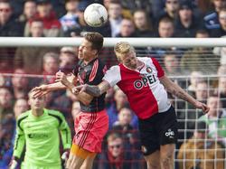 Lex Immers (r.) gaat het kopduel aan met Niklas Moisander (l.) in het strafschopgebied van Ajax. De Fin springt hoger en kopt de bal weg. (02-03-2014)