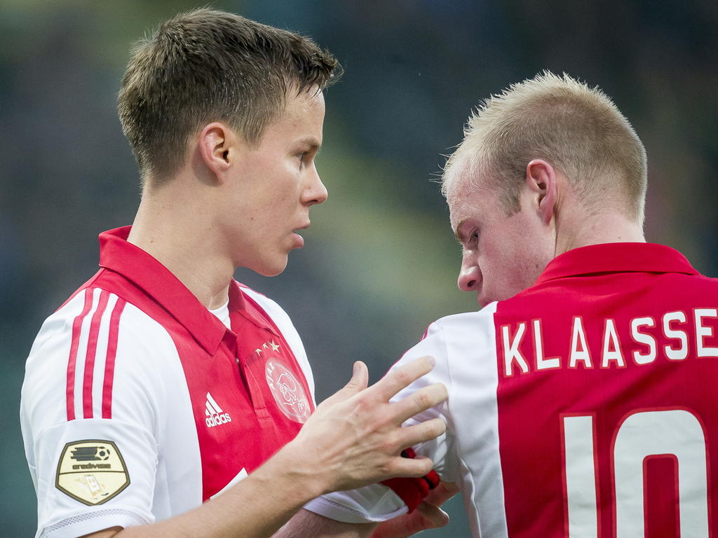 Niklas Moisander (l.) schuift tijdens ADO Den Haag - Ajax de aanvoerdersband om de arm van Davy Klaassen (r.). (30-11-2014)
