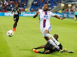 Alexandre Lacazette (l.) wordt in de beginfase van de wedstrijd tussen Olympique Lyon en SM Caen neergelegd door Mouhamadou Dabo (r.). (19-08-2016)
