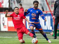 Hakim Ziyech (l.) voert zijn verdedigende taak uit en probeert tijdens de wedstrijd FC Twente - Feyenoord Miquel Nelom (r.) af te stoppen. (10-04-2016)