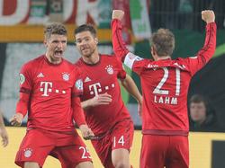 Thomas Müller (l.) viert een treffer met Xabi Alonso (m.) en Philipp Lahm (r.) tijdens het duel in de DFB-Pokal tussen VfL Wolfsburg en Bayern München. (27-10-2015)