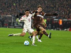 FC St. Paulis Abwehrspieler Eric Smith (r) verletzt sich beim Spiel gegen den FC Bayern.  