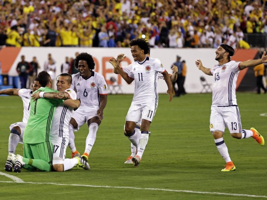 De spelers van Colombia stormen naar doelman David Ospina (l.) nadat de Zuid-Amerikanen de penaltyserie van Peru winnen in de kwartfinale van de Copa América. (18-06-2016)