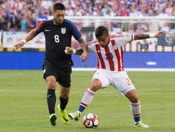 Clint Dempsey (l.) zet druk op Víctor Ayala (r.) van Paraguay tijdens de laatste wedstrijd in de groepsfase van de Copa América. (12-06-2016)