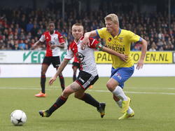 Jordy Clasie (m.) en Bob Schepers (r.) vechten een duel uit tijdens SC Cambuur - Feyenoord. Terence Kongolo kijkt op de achtergrond toe. (26-10-2014)