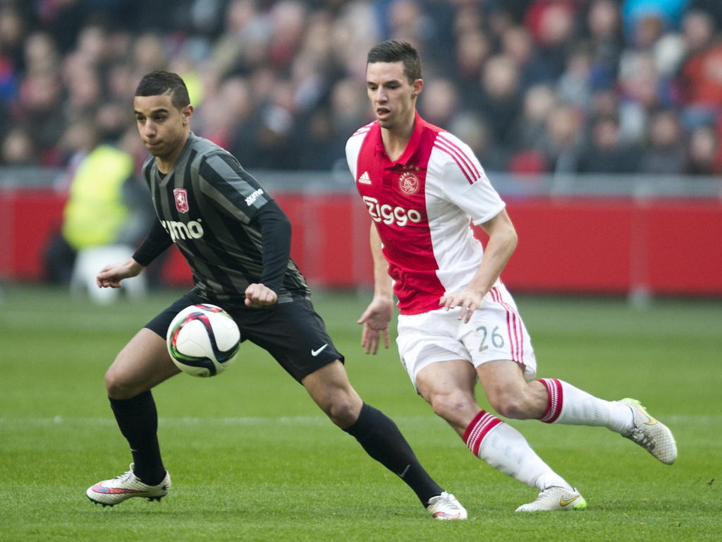 Bilal Ould-Chikh (l.) draait tijdens Ajax - FC Twente behendig weg als Nick Viergever druk wil zetten op de bal. (15-02-2015)