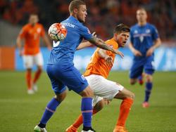 Klaas Jan Huntelaar (r.) is in de kwalificatiewedstrijd tegen IJsland de bal kwijt. Ragnar Sigurðsson heeft ook geen idee waar het speeltuig is. (03-09-2015)