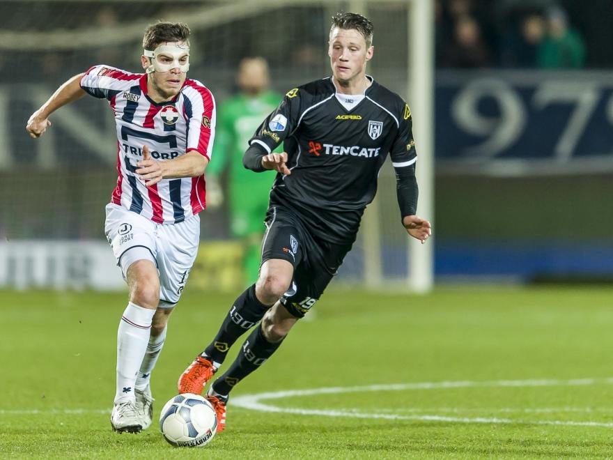De gemaskerde Dries Wuytens stoomt op met de bal aan zijn voet, terwijl Wout Weghorst (r.) druk probeert te zetten. (29-01-2016)