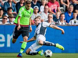 Hakim Ziyech (l.) snelt langs zijn directe tegenstander Robin Gosens (r.) van Heracles Almelo. (18-09-2016)