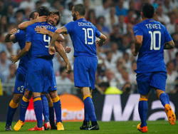 Doelpuntenmaker Álvaro Morata (9), die ingetogen juicht, wordt na zijn belangrijke gelijkmaker tegen Real Madrid bedolven door spelers van Juventus. (13-05-2015)